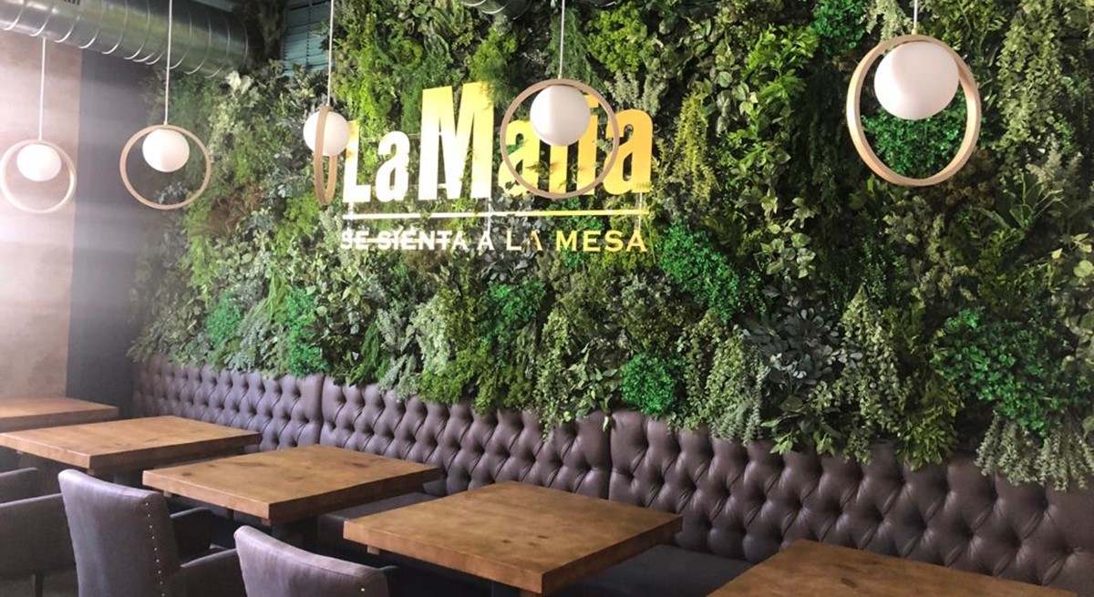 Interior del restaurante "La Mafia se sienta en la mesa" con mesas elegantemente dispuestas.